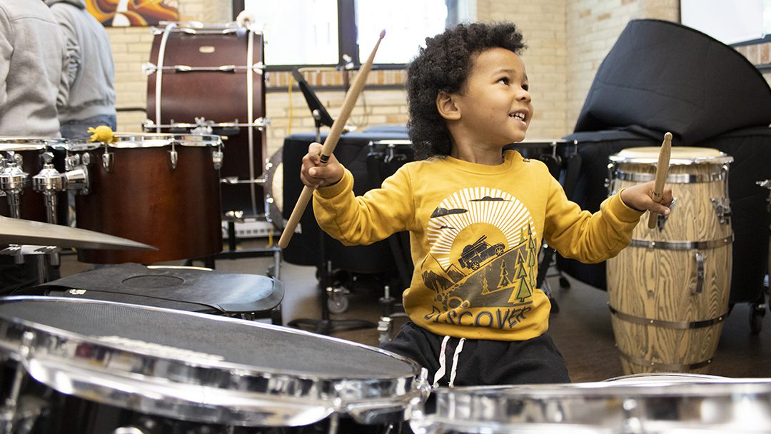 Musical Storytime student playing drums