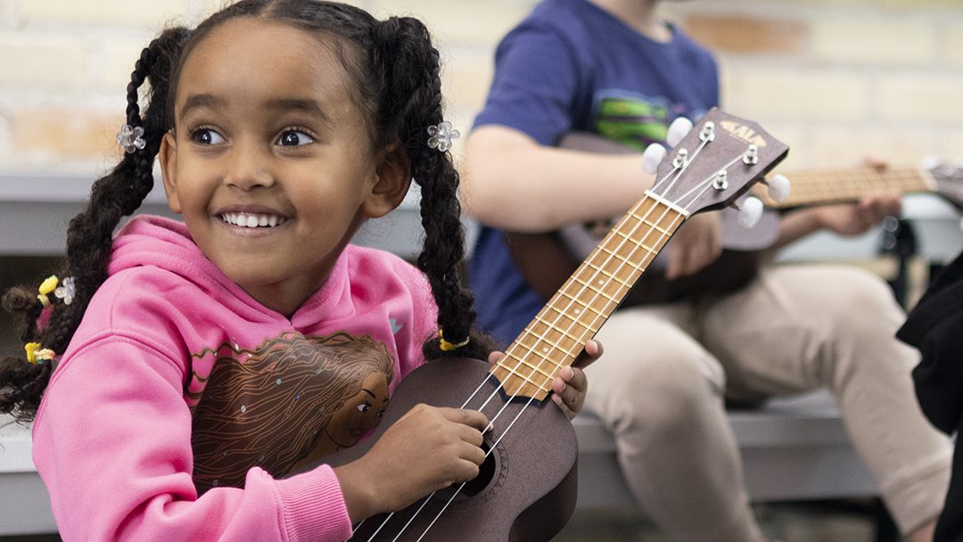 Student holding an ukulele