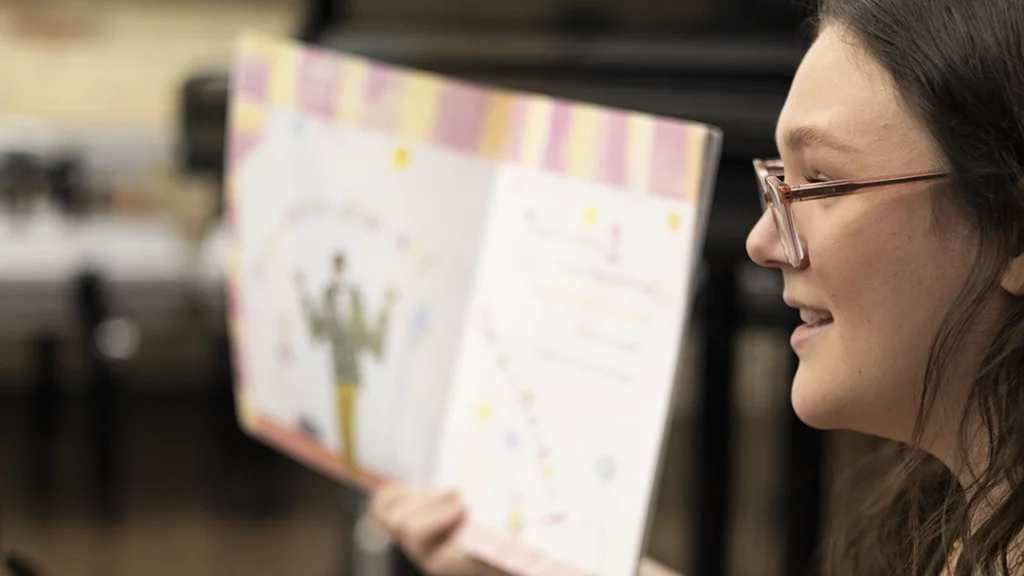 Musical Storytime instructor, McKenna Ogg, reading a book to the class