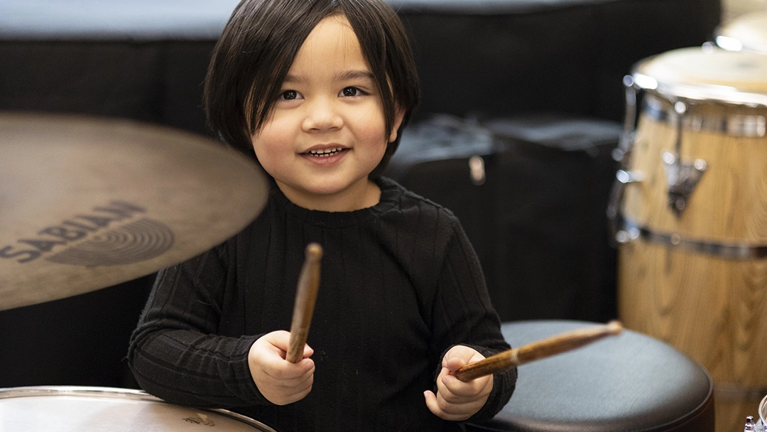 Adventures in Music student playing the drums.