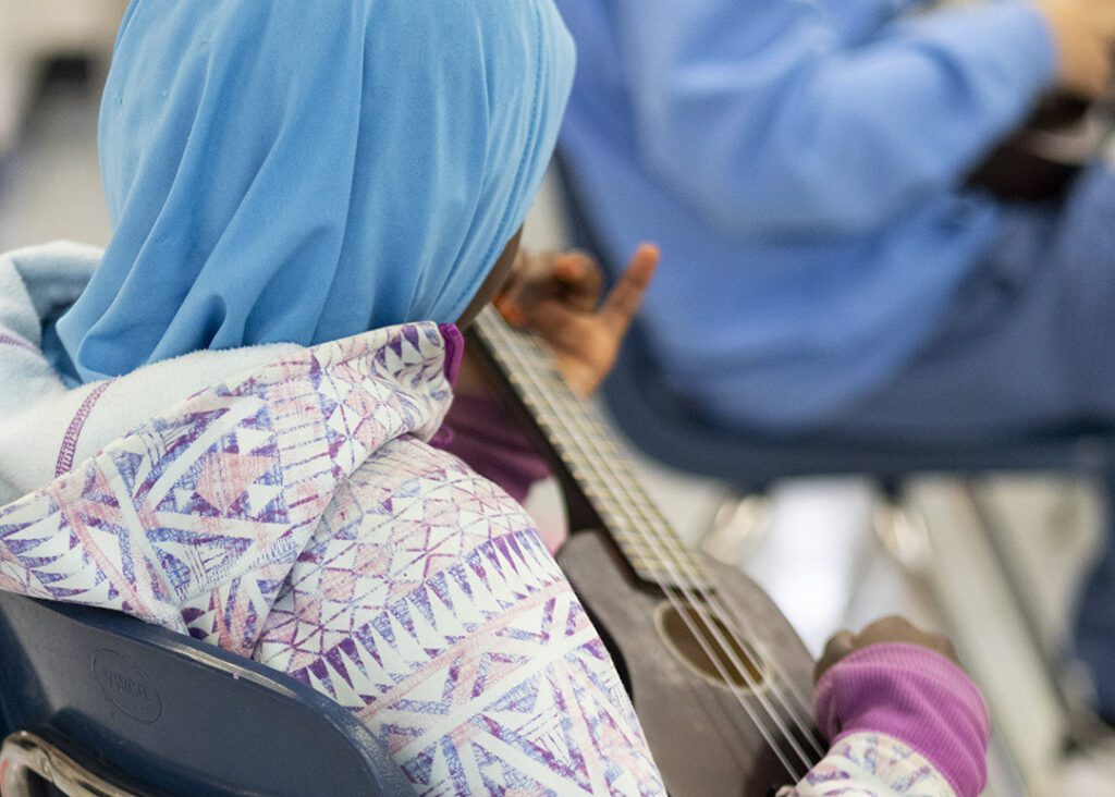 Student at David Livingstone school playing ukulele