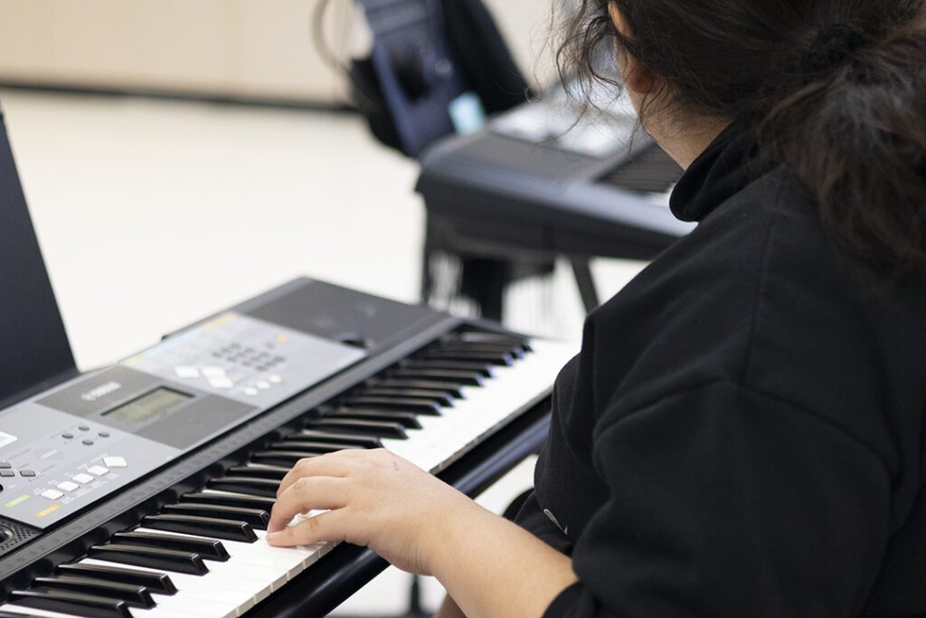 Student at William Whyte school playing a keyboard
