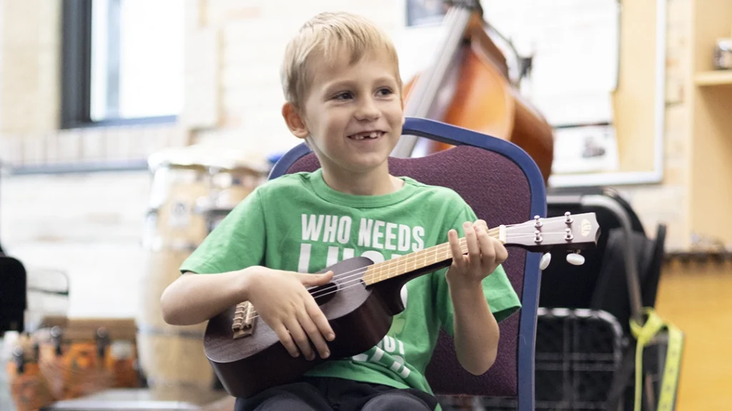 Intro to Instruments student holding an ukulele.