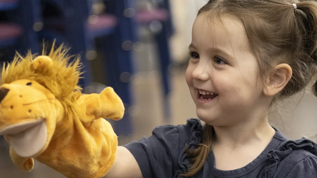 Intro to Musical Theatre student holding a puppet.