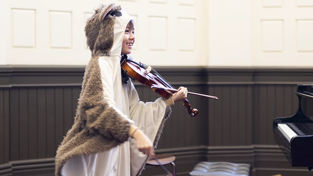 Student playing violin at Halloween recital